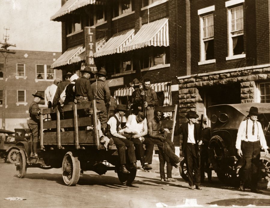 3rd June 1921: injured and wounded men are being taken to hospital by National guardsmen after racially motivated riots, also known as the "Tulsa Race Massacre", during which a mobs of white residents attacked black residents and businesses of the Greenwood District in Tulsa, Oklahoma, US. (Photo by Hulton Archive/Getty Images)